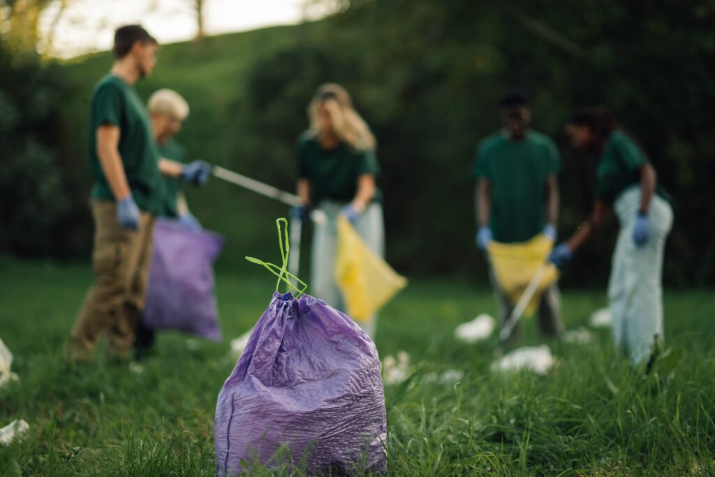 volunteers collecting trash in garbage bag in a public park