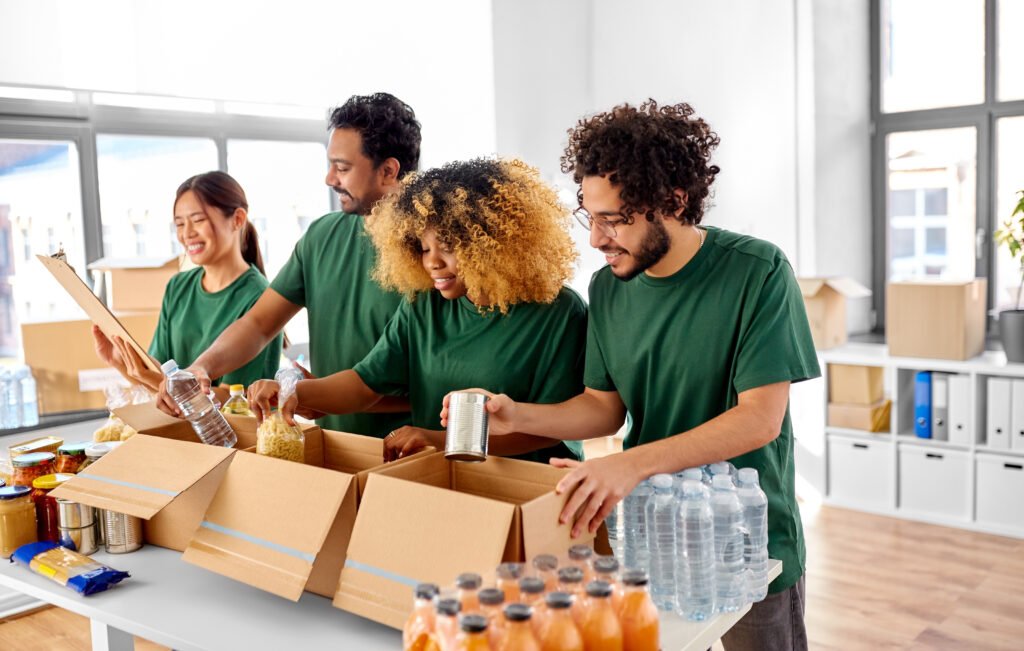 happy volunteers packing food in donation boxes